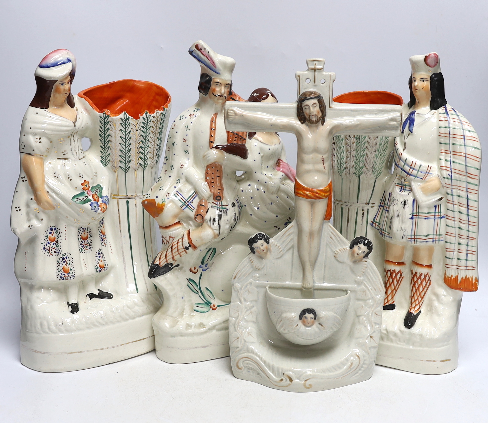Four Staffordshire figure groups; a Crucifixion stoup, a pair of vases, a Scottish group and two related reference books, tallest 34cm